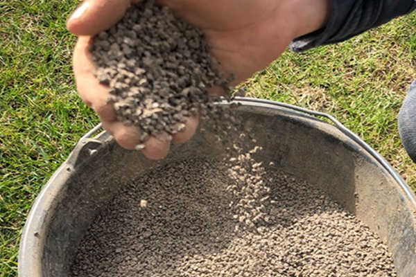 Aaanlegbemesting over de graszoden strooien